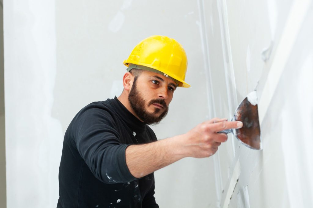 Application de crépi mural pour une finition lisse et durable, parfaite pour embellir vos façades extérieures.